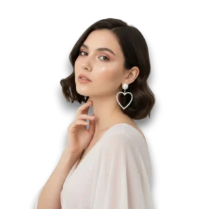 Beyaz fon üzerinde mankenin kulağında zirkon taşlı kalp figürlü incili küpenin yandan görünümü.