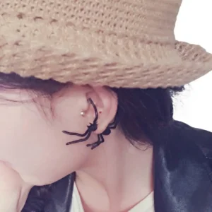 Siyah Renk Tarantula Tasarım Gotik Küpe, hasır şapka kombininde sol profil çekim.