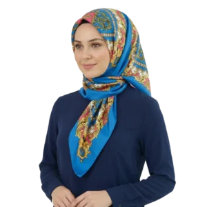 Manken kadın üzerinde tesettür başörtüsü tarzında bağlanmış mavi renk etnik desenli saten eşarp TikiTonki