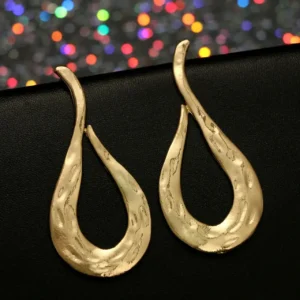 Pirinç Küpe Kabartma Model Gold Tasarım, doğal fonda detay çekim.