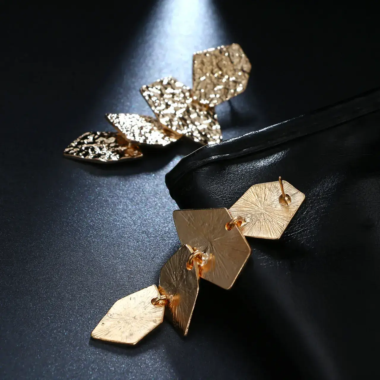 Yaprak Küpe Asimetrik Model Gold Tasarım, bir çift ürün genel görünüm, siyah fon.