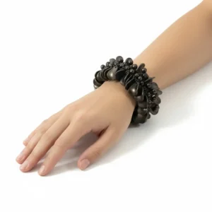 Beyaz arka planda manken bileğinde yaprak motifli antik metal chunky bileklik yakın pozu.